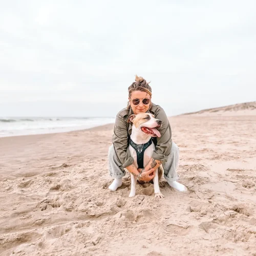 Femme avec American Staffordshire Terrier à la plage